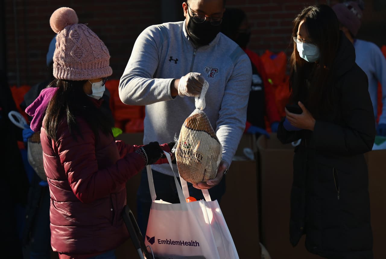 <b>Largas filas para recibir donaciones de comida (20 de noviembre).</b> Según
<a href="https://www.feedingamerica.org/hunger-in-america/facts?s_src=Y20YP1B1Z&s_keyword=feeding%20america&s_subsrc=c&_ga=2.206837587.1133148200.1606320160-391345894.1606320160&_gac=1.12765125.1606320160.CjwKCAiAnvj9BRA4EiwAuUMDf8Yed06SIsy0ApOupSGyJkR_iTEPyROFzZeB_ZyqGzPx9g2jWCzMIBoCpjMQAvD_BwE"><u>Feeding America</u></a>, 50 millones de estadounidenses podrían necesitar
<a href="https://www.feedingamerica.org/hunger-in-america/facts?s_src=Y20YP1B1Z&s_keyword=feeding%20america&s_subsrc=c&_ga=2.206837587.1133148200.1606320160-391345894.1606320160&_gac=1.12765125.1606320160.CjwKCAiAnvj9BRA4EiwAuUMDf8Yed06SIsy0ApOupSGyJkR_iTEPyROFzZeB_ZyqGzPx9g2jWCzMIBoCpjMQAvD_BwE">ayuda alimentaria para el final de 2020</a> y calculan que 40% de las personas han recibido esta ayuda por primera vez durante la pandemia. En la foto voluntarios entregan pavos en Brooklyn, Nueva York, para la tradicional cena de Acción de Gracias.