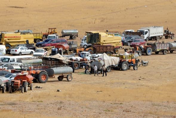 Atrás se quedan miles de coches, aparcados a lo largo de la alambrada en la frontera de Siria y Turquía.