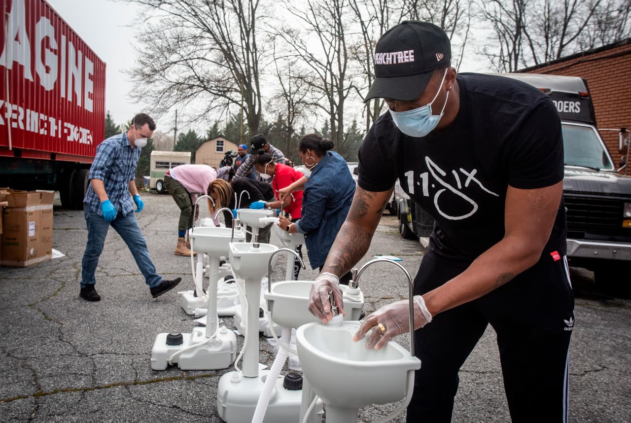<b>Lavamanos en las calles. </b>En College Park, Georgia, un grupo de voluntarios ensambla una estación de lavado de manos portátil, en la tarde del 19 de marzo. Las autoridades han insistido en que mantener las manos limpias es una de las herramientas más útiles para detener la propagación del covid-19.