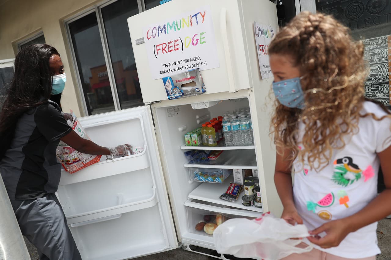 En esta foto, Sherina Jones (a la izquierda), quien según informa el Miami Herald estableció uno de estos refrigeradores comunitarios, ayuda a otra residente del área a poner los alimentos que está donando. 
<br>