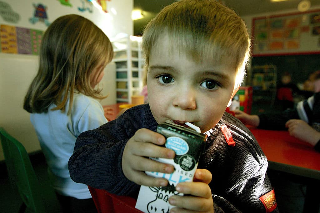 Niño bebiendo leche de caja