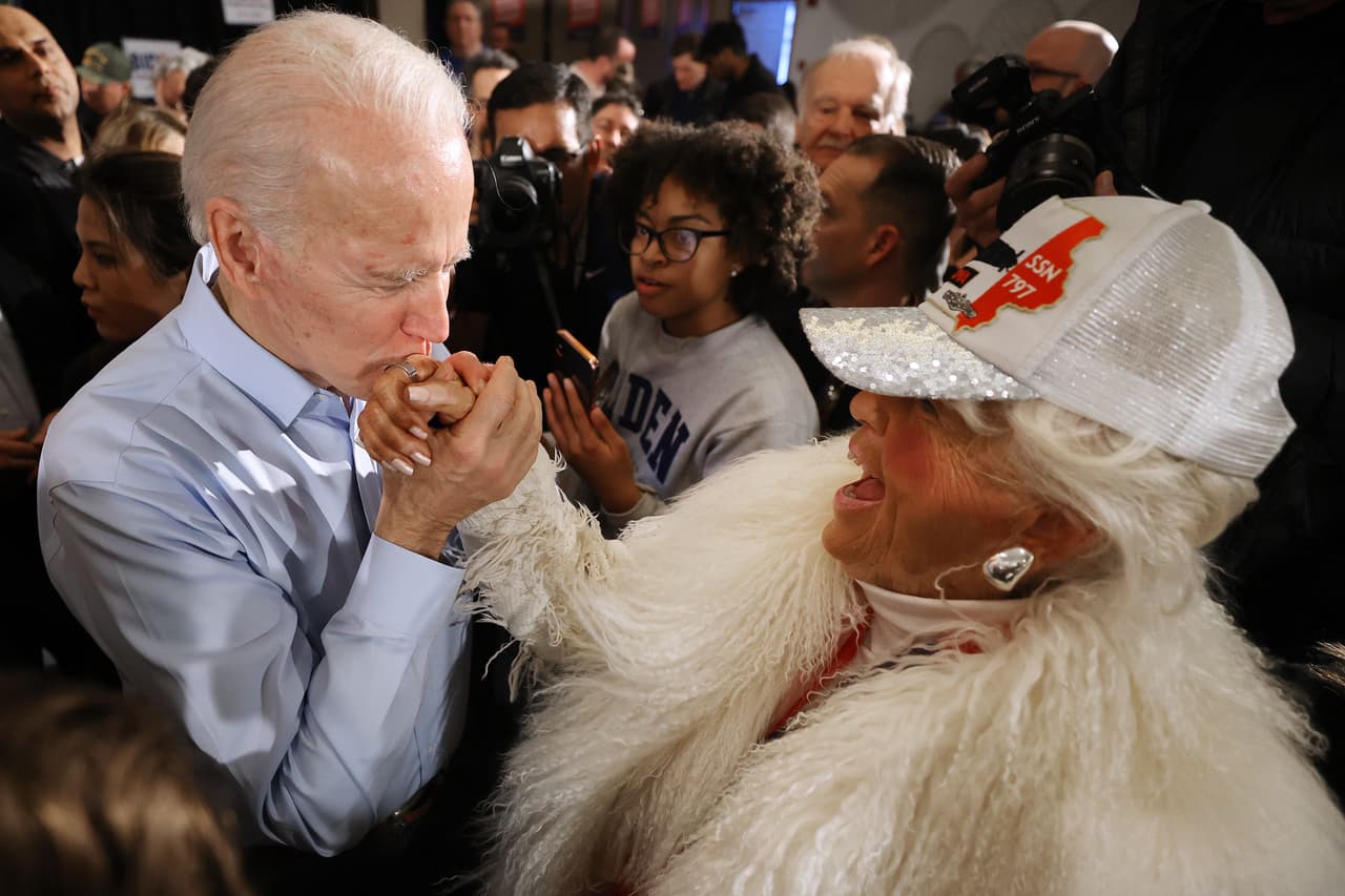 En esta imagen del 27 de enero de 2020 el candidato demócrata 
<a href="https://www.univision.com/temas/joe-biden">Joe Biden</a> besa la mano de una seguidora en Marion, Iowa, cuando todavía estaban en el proceso de primarias. Esto sucedió cuando apenas se reportaban los primeros casos de covid-19 en Estado Unidos, unas semanas después un gesto así se convirtió en imposible.