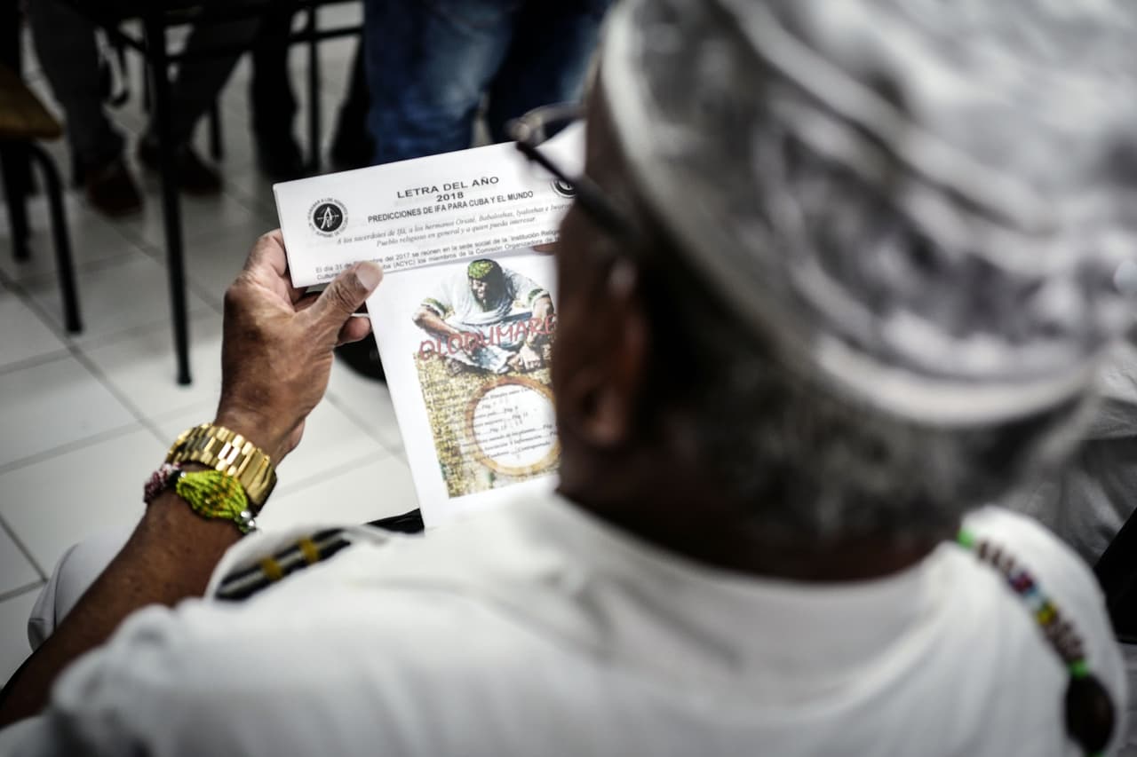 An Afro-Cuban Yoruba religion priest reads the "Letter of the Year" -which lists predictions made by Cuban Santeros for the new year- during a press conference in Havana on January 02, 2018. The babalawos (priests of Cuban Santeria) will pray this year to the Elegua deity, owner of the roads and destiny, to continue opening paths for the island, as they say she did in previous years. The prediction is made using the "Ifa Oracle", a complex and extensive divinatory system brought to America by the Yoruba slaves, which consists of 16 major signs and 240 possible combinations. / AFP PHOTO / ADALBERTO ROQUE (Photo credit should read ADALBERTO ROQUE/AFP/Getty Images)