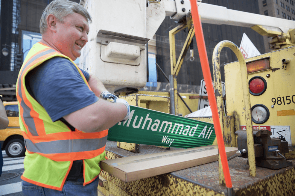 Con evidente satisfacción el encargado de colocar el letrero.
