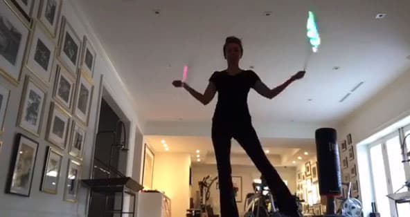 Thalía haciendo cardio girando dos luces como si fueran cintos en fuego.