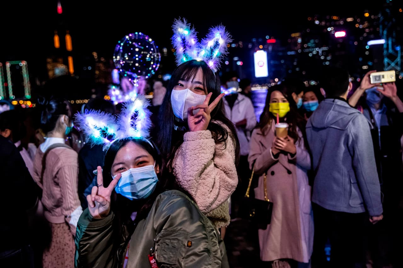 Dos mujeres posan junto al puerto de Victoria en Hong Kong el 1 de enero de 2021, a pesar de las restricciones del coronavirus covid-19 y la cancelación de los fuegos artificiales de Año Nuevo, la gente se reunió para celebrar el Año Nuevo.