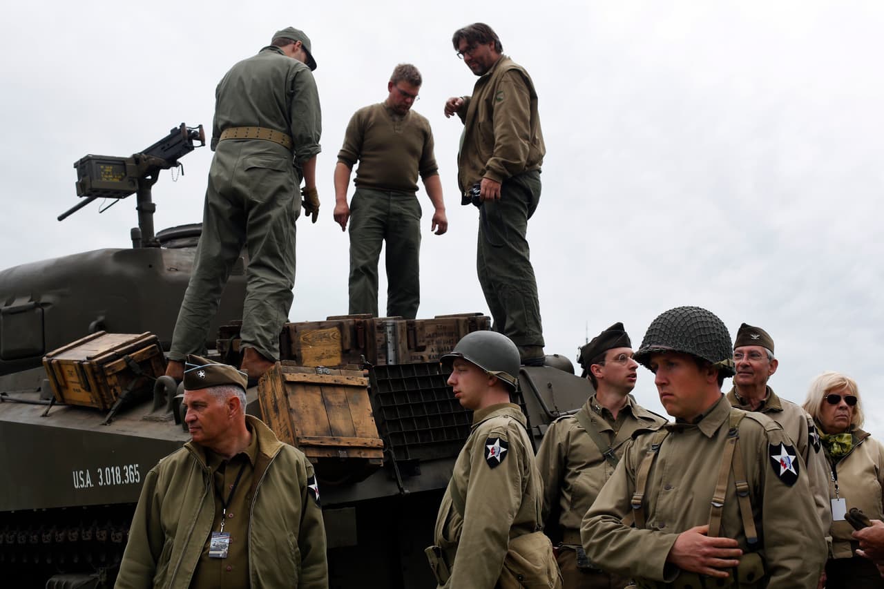 Entusiastas franceses se reúnen alrededor de un tanque Sherman mientras recrean un campamento estadounidense el martes 4 de junio de 2019 en Vierville-sur-Mer, Normandía.
