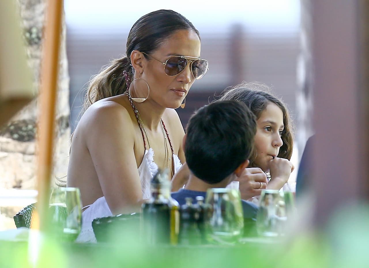 Photo © 2016 Fame Flynet USA/The Grosby Group Miami, November 27, 2016. Jennifer Lopez goes braless in a strappy white jumper as she shops with her twins Max and Emme in Miami.
