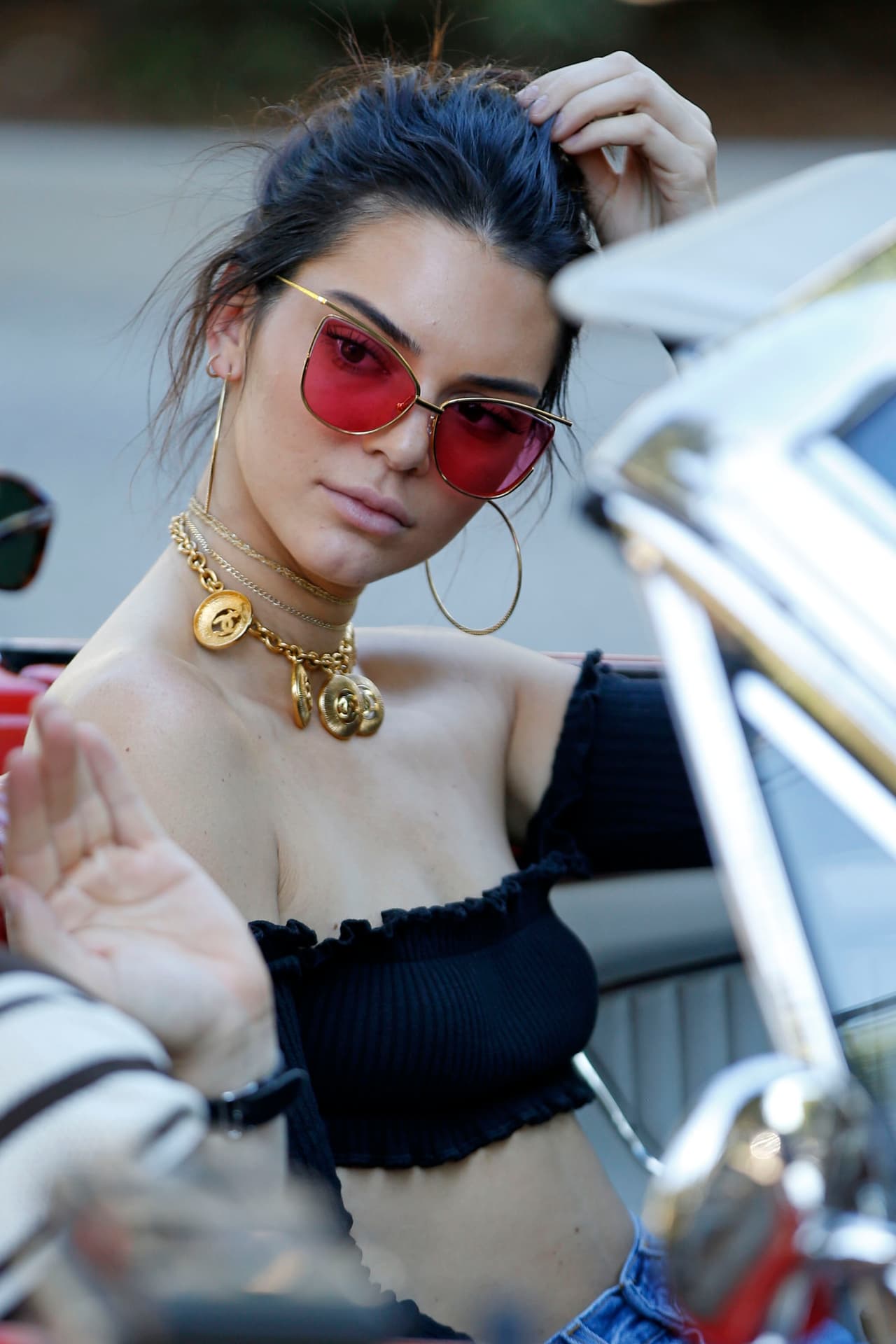 Kendall con un crop-top negro, prestando atención a su amigo.