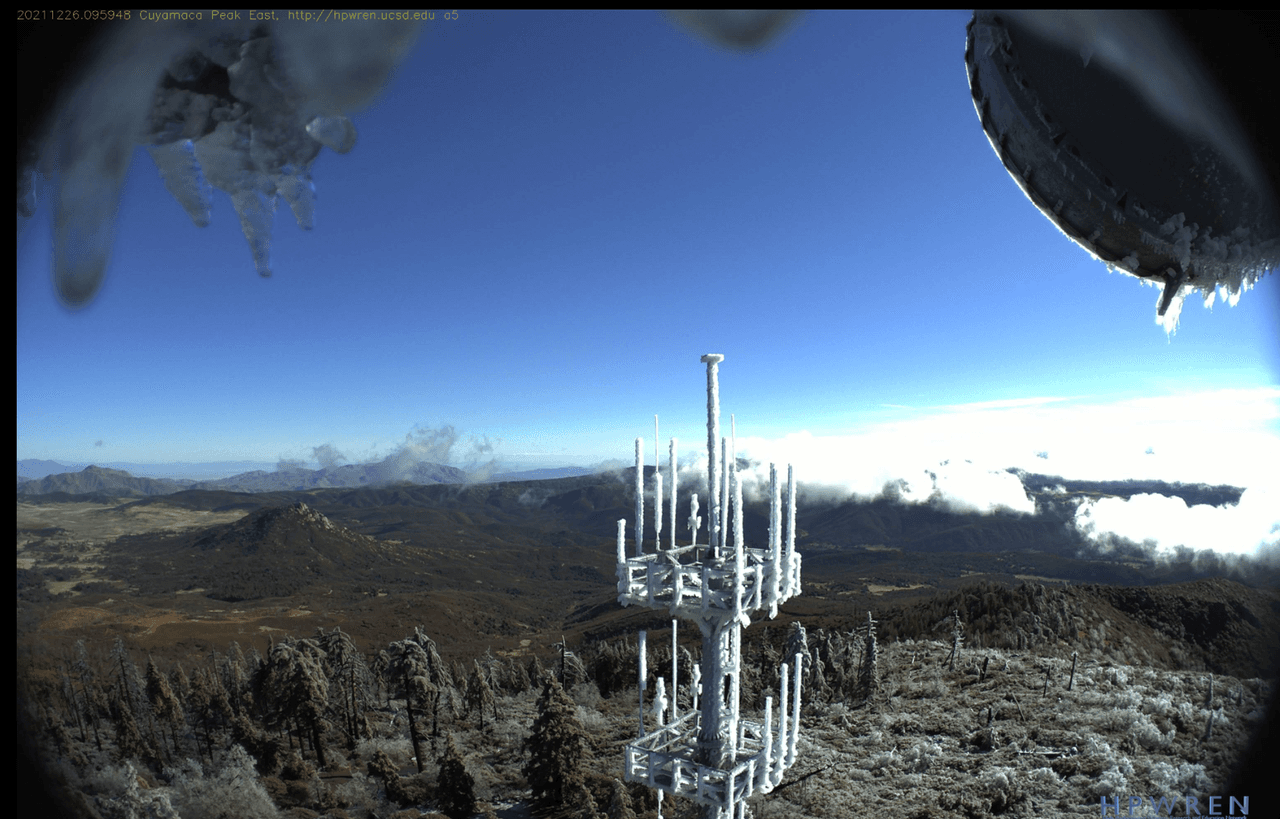 En esta otra toma, en las cámaras de Cuyamaca Peak, se aprecian las antenas cubiertas de nieve y un poco de escarcha en los árboles en la zona. Se espera que en los pr´oximos días la nieve cubra todo el terreno de la montaña.