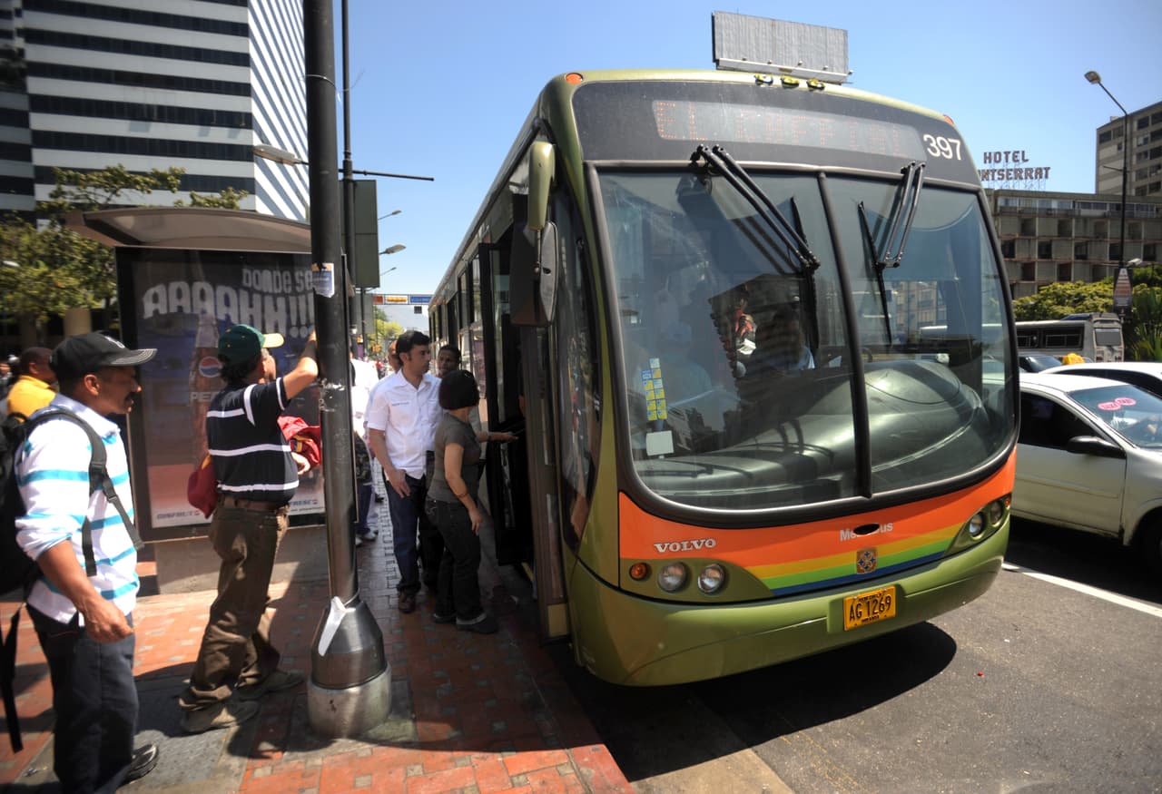 Gente se sube a un autobús en Caracas.
