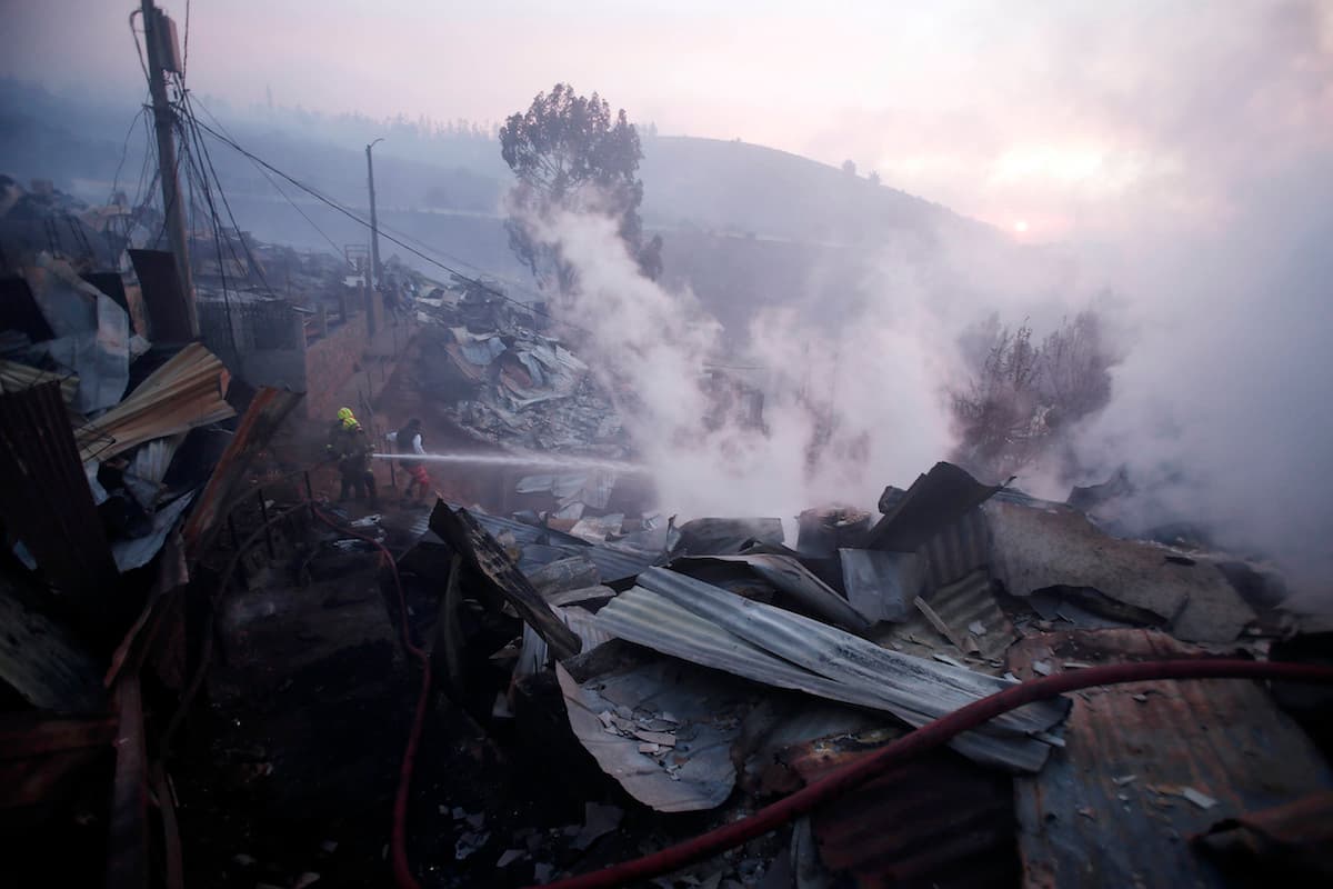 Brigadas de bomberos mojan las viviendas con material retardante para intentar salvarlas.