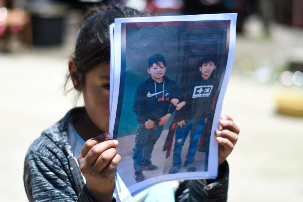 Una niña sostiene una imagen de los dos primos guatemaltecos de Tzucubal fallecidos en la tragedia de San Antonio.