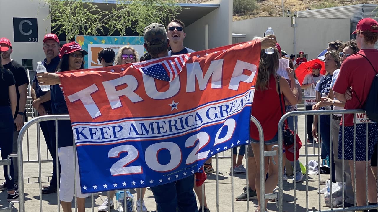 Con banderas, gorras y diferentes artículos promocionales esperan al presidente Trump en Phoenix.