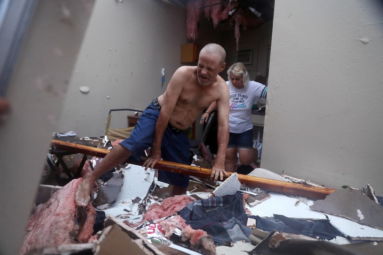 Billy y Donna Raney caminan sobre los restos de su apartamento de Rockport, después de que el huracán Harvey lo destruyera.