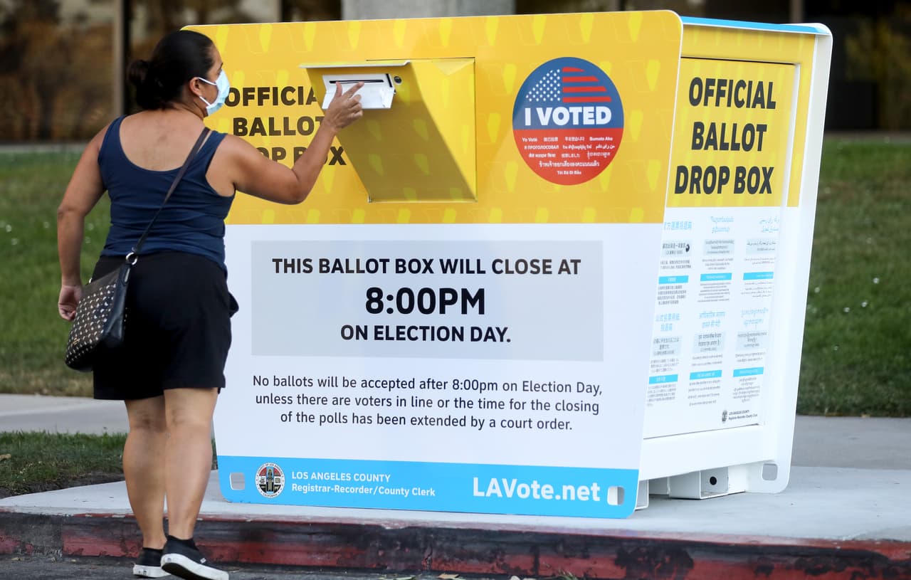 Una votante coloca una boleta en un buzón oficial de votación por correo en Los Ángeles, el 14 de octubre. A solo 18 días de la elección, más de un millón de californianos han devuelto sus boletas de votación recibidas por correo, estableciendo un récord para cualquier elección de California. 
<br>