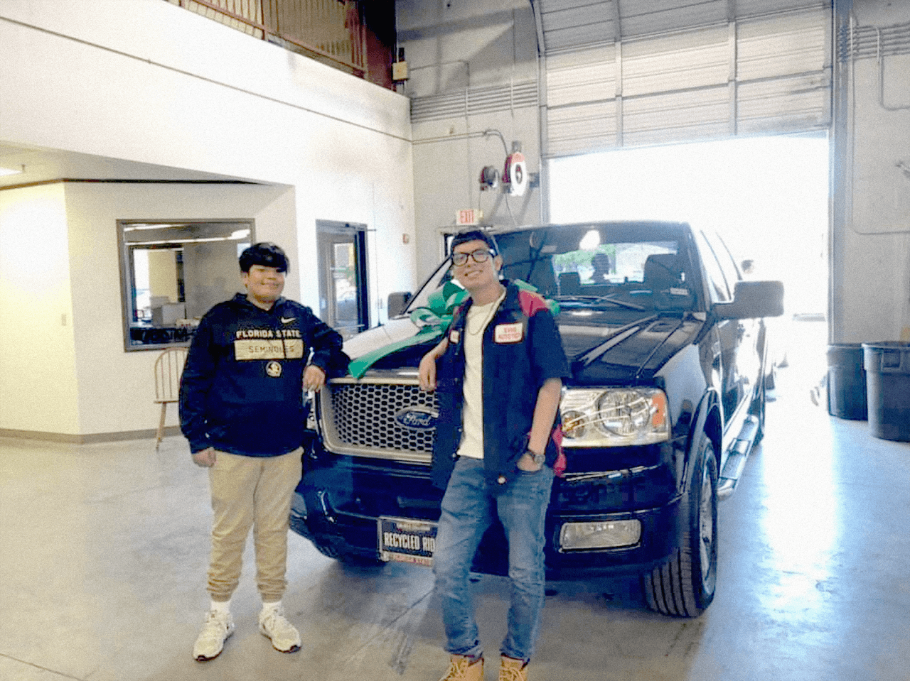 Cristian y Daniel Alcántara posan junto a la troca que pertenecía a sus padres, quienes murieron hace 8 años en un accidente vial en Florida.