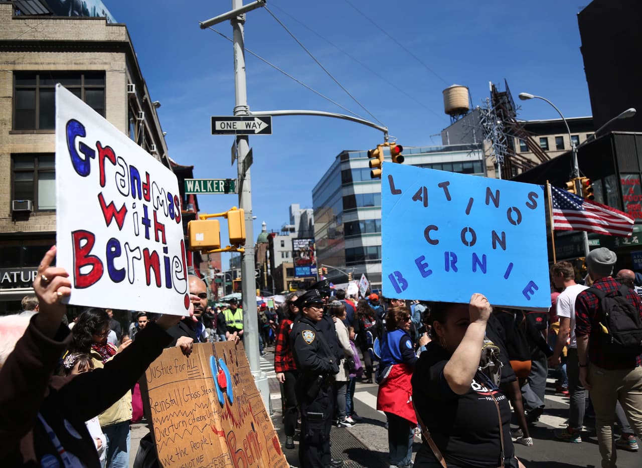 Una mujer con un letrero que dice “Abuelas con Bernie” y otra mujer con uno que dice “Latinos con Bernie” marchan por la Centre St. en Nueva York el 15 de abril de 2016.