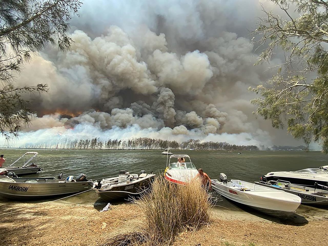 Según Scott Morrison, primer ministro de Australia, la crisis por los incendios podría durar meses “Esto continuará hasta que tengamos lluvias decentes que puedan lidiar con algunos de los fuegos que llevan ardiendo meses”, explicó Morrison a los medios. En la fotografía el humo de los incendios detrás del lago Conjola, al sureste del país.