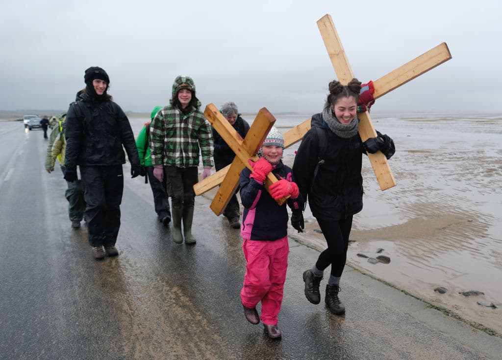 Peregrinos ingleses cargan su propia cruz de madera en su camino anual a la sagrada isla de Lindisfarne, Inglaterra.