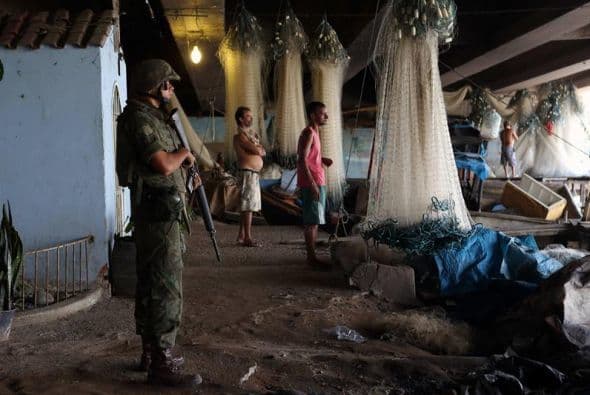 Militares de las Fuerzas Armadas brasileñas hacen guardia en la colonia de pescadores del complejo de favelas de Maré en Rio de Janeiro.