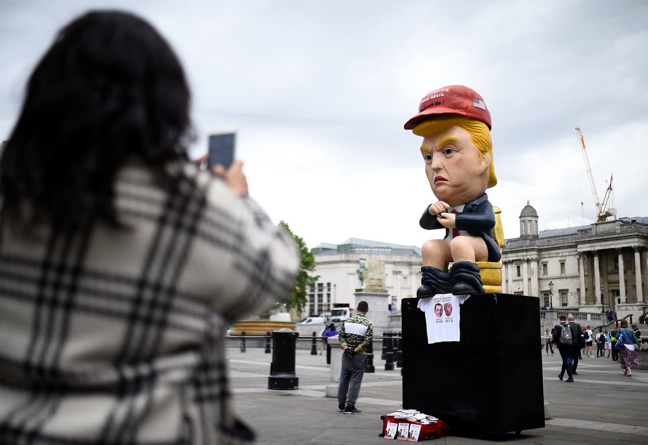 Un manifestante toma una fotografía a una estatua del presidente Trump durante la protesta convocada en la plaza Trafalgar, de Londres.