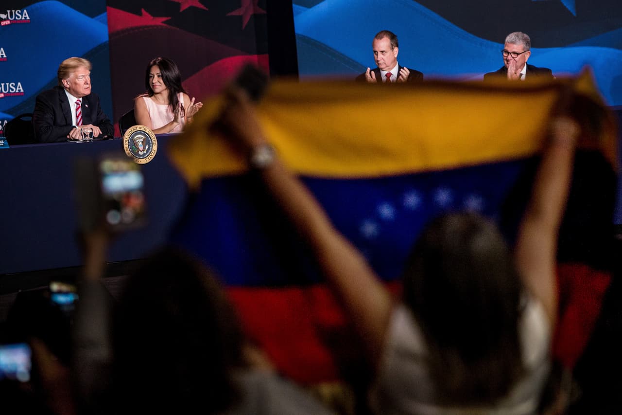 Según cifras de la OIM basadas en estadísticas del Departamento de Seguridad Nacional de EEUU, 12,242 venezolanos con visado de turistas superaron el tiempo autorizado para permanecer legalmente en el país desde el 1 de octubre de 2016 al 30 de septiembre de 2017. Desde 2004 hasta 2015 se concedieron 10,000 residencias legales por año a ciudadanos venezolanos y en 2016 se concedieron 5,662. Desde 2006 hasta 2016, un total de 64,000 venezolanos adquirieron la nacionalidad estadounidense. En la fotografía, una mujer muestra una bandera de Venezuela al presidente Donald Trump, durante una reunión con pequeños empresarios en Hialeah, Florida, en abril de 2018.