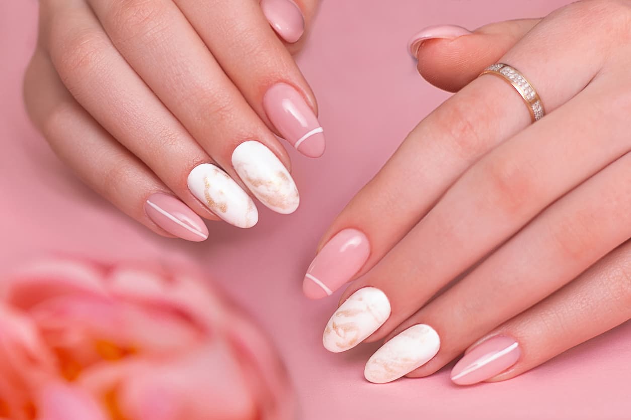 Si los nail arts anteriores te parecendemasiado sencillas, prueba combinando varias técnicas. El efecto marmoleado le agrega un estilo original y elegante a tus manos. No olvides dejar al menos dos de tus uñas con el acabado espejo.