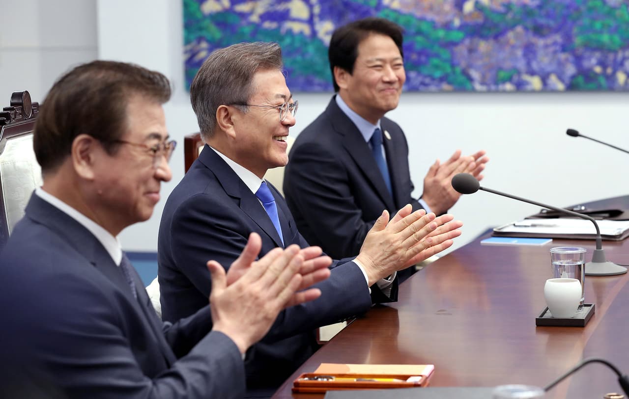 Moon Jae-in y su equipo de ministros en un momento de la reunión, aplaudiendo la celebración del encuentro histórico.