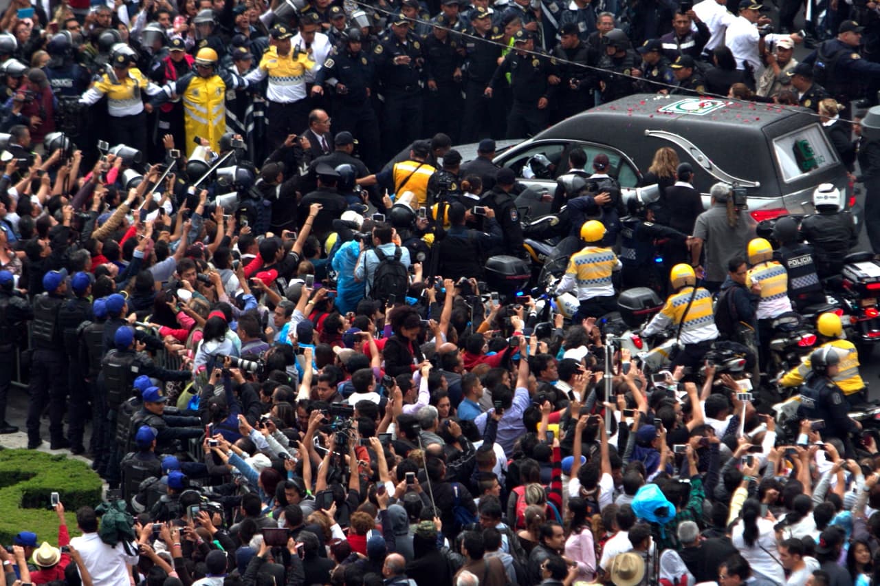Miles de personas esperan el paso de los restos de Juan Gabriel en las calles de la capital de México