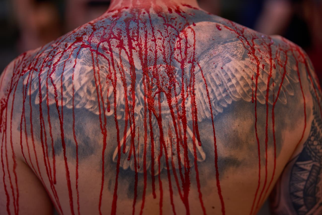 Un manifestante deja ver su espalda cubierta de sangre en representación de cómo matan a los toros