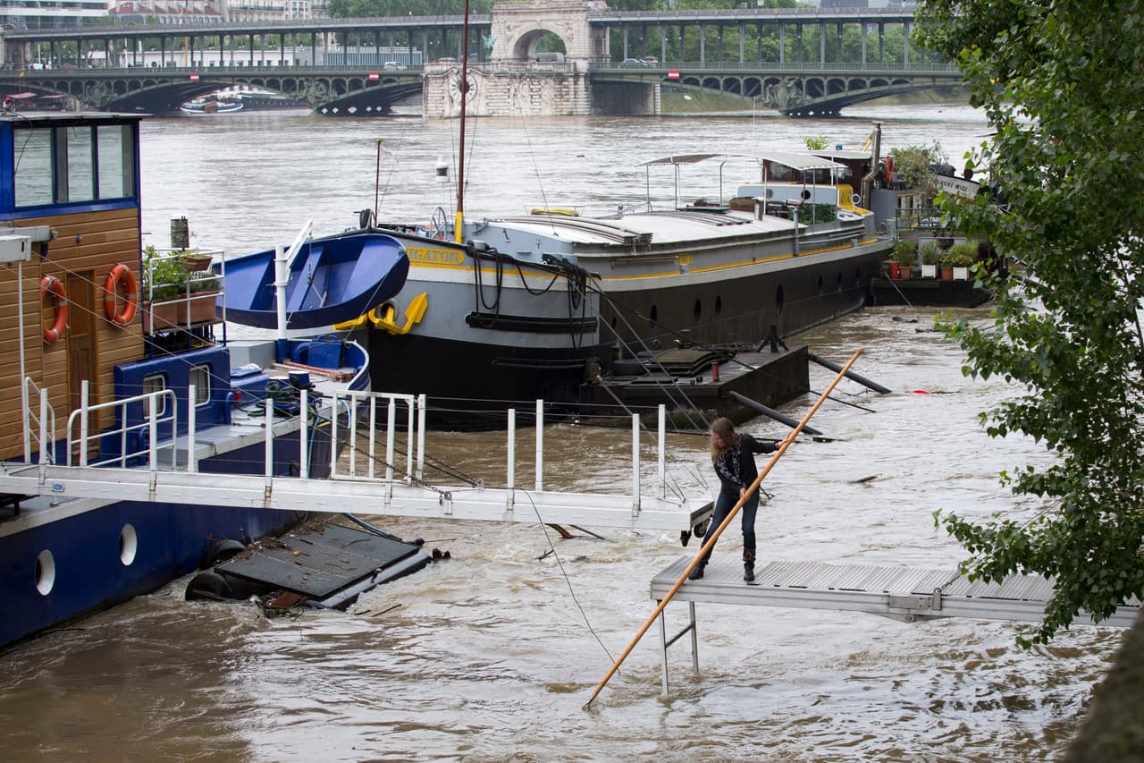 Voluntarios intentan remover objetos del río Sena, traídos por la crecida.