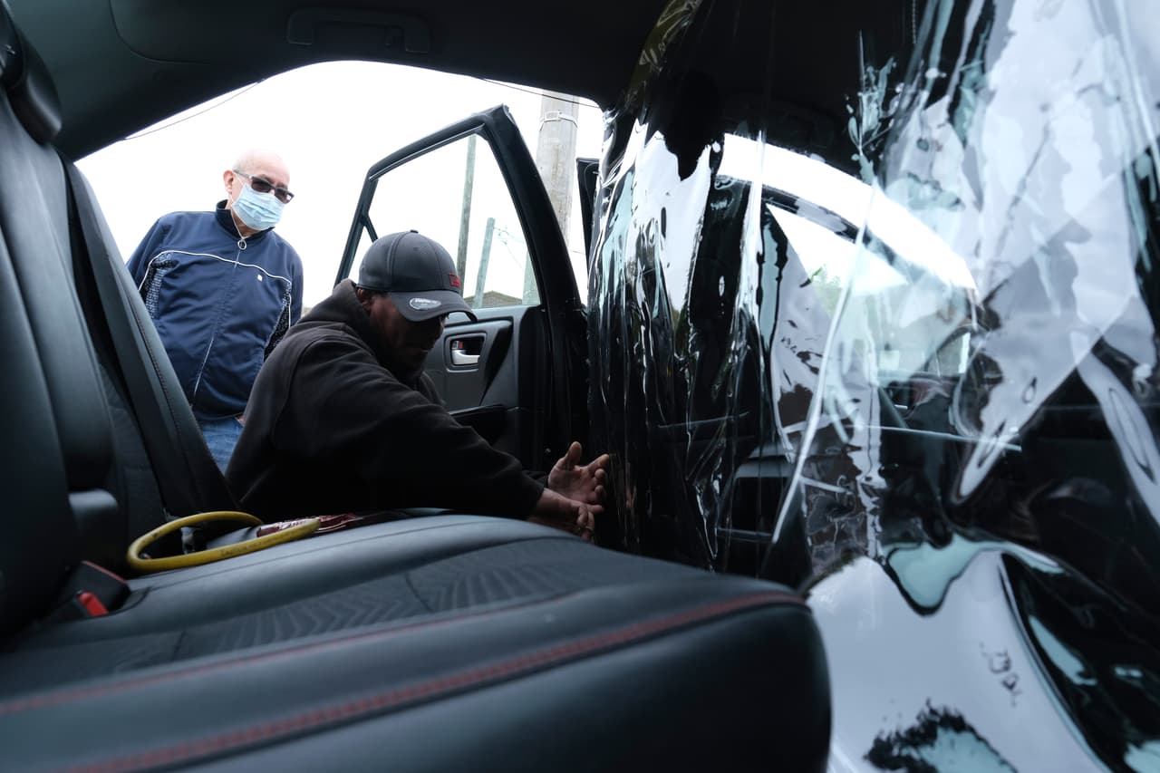 Un conductor de Uber de El Bronx, Nueva York, instala una barrera de plástico transparente para mantenerse aislado de los pasajeros. 6 de mayo.