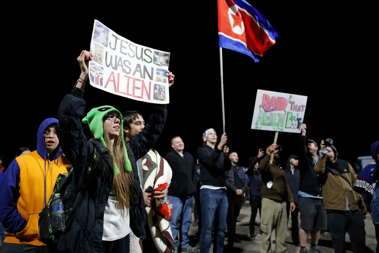 Una multitud canta y protesta en la entrada de Campo de Pruebas y Entrenamiento de Nevada cerca del Área 51 este viernes en Rachel, Nevada. El evento en Facebook inicial fue borrado por la red social, pero los creadores del evento crearon otro al que luego respondieron otras 1,600 personas. Matty Roberts, uno de los creadores, dijo que creó el evento como una broma.
<br>