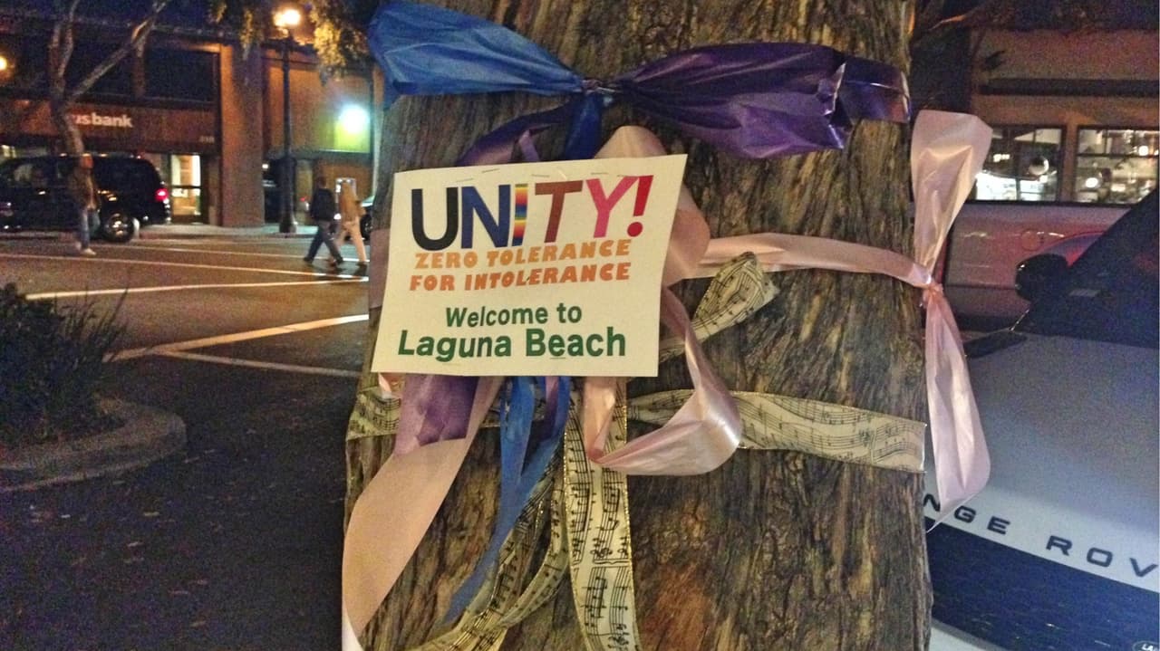 "Unidad. Cero tolerancia contra la intolerancia. Bienvenidos a Laguna Beach". Este tipo de letreros fueron colocados con moños en diversas partes de la ciudad.