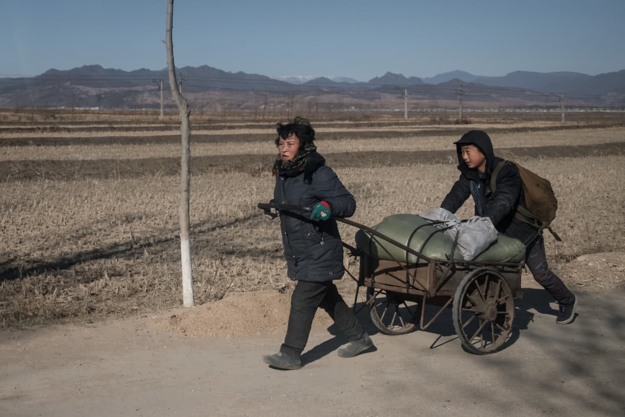 En esta foto tomada el 19 de noviembre se ve a una madre y su hijo transportando madera en un camino cerca a Kiliju. ED JONES/AFP/Getty Images
