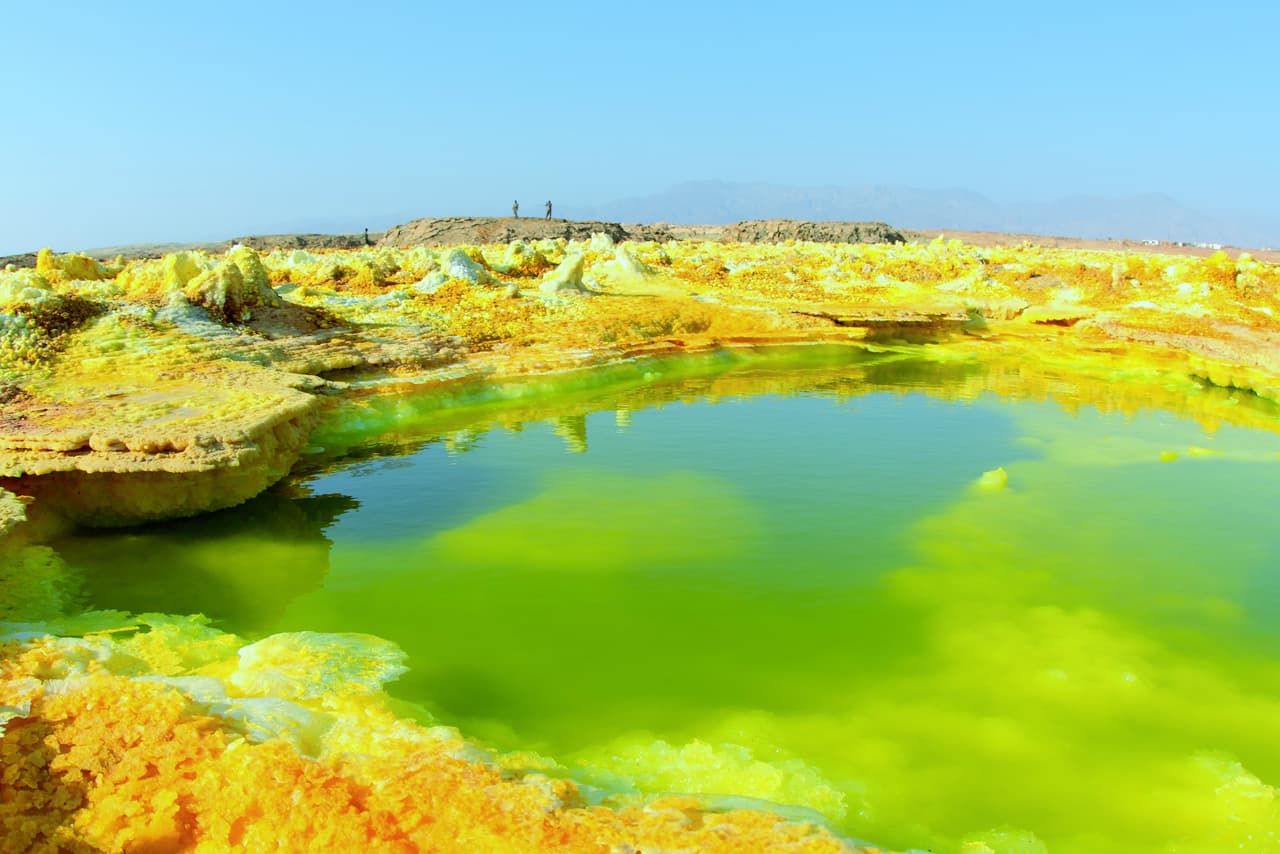 <b>Dallol, Etiopía</b>
<br>
<br>Esta zona de volcanes y géiseres es una de las más calientes del mundo. Su temperatura media anual es de 94 grados fahrenheit (34 centígrados), pero en verano puede llegar a los 116 (47 C). El amarillo brillante que vemos en la foto es el resultado de la reacción entre el azufre y la sal.
<br>