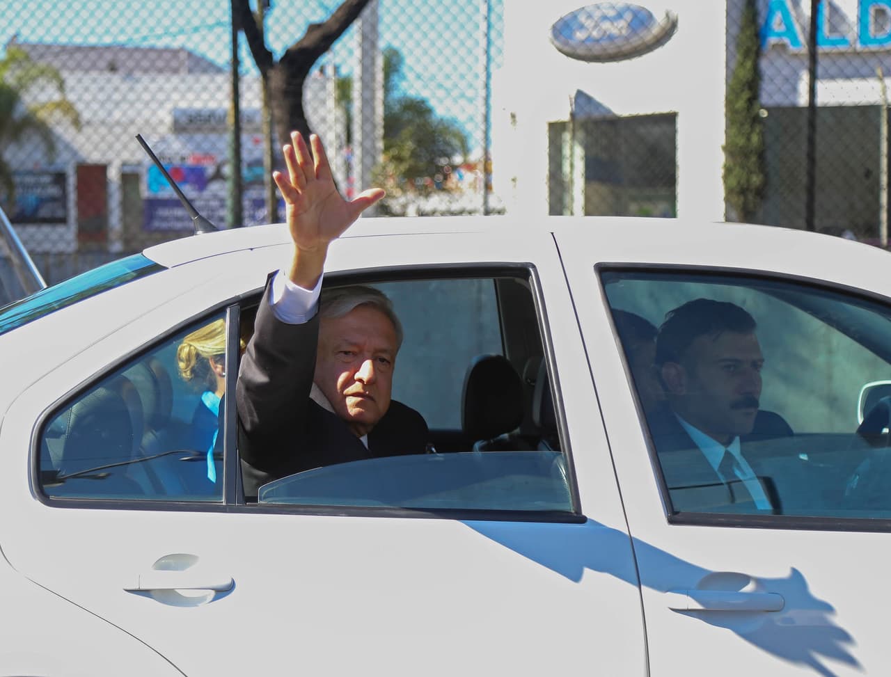 Andrés Manuel López Obrador saluda desde el vehículo en el queviajó rumbo a la Cámara de Diputados para ser investido como presidente.