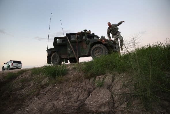 En esta imagen vemos a tropas de la Guardia Nacional de Texas, vigilando a bordo de vehículos militares a la orilla del Río Grande.