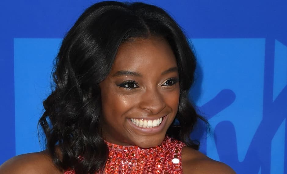 Simone Biles le fue fiel a su amado 
<a href="http://www.univision.com/estilo-de-vida/belleza/el-glitter-de-simone-biles-y-propuestas-de-maquillaje-para-brillar-como-ella-fotos"><i>glitter</i></a>. Esta vez no optó por delineados llenos de brillo, pues aplicó un poco de sobra con efecto brillante en sus párpados. La piel lució luminosa, muy natural y como siempre su mejor accesorio fue la sonrisa que la caracteriza.
<br>