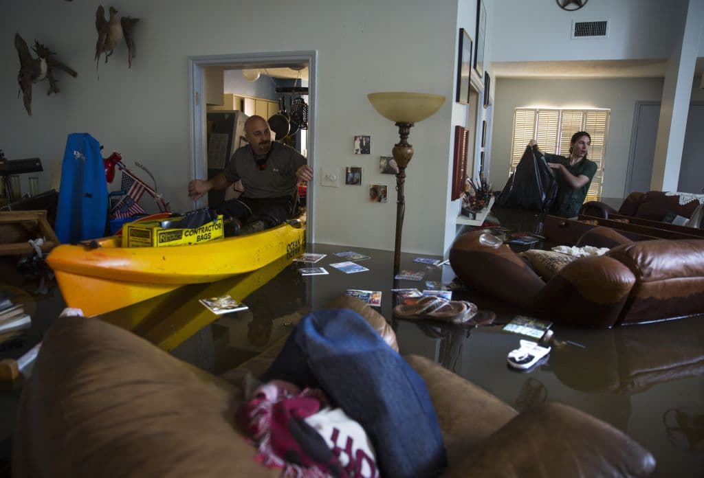 HOUSTON, TX - AUGUST 29: Larry Koser Jr. (L) and his son Matthew look for important papers and heirlooms inside Larry Koser Sr.'s house after it was flooded by heavy rains from Hurricane Harvey August 29, 2017 in the Bear Creek neighborhood of west Houston, Texas. The neighborhood flooded after water was release from nearby Addicks Reservoir. (Photo by Erich Schlegel/Getty Images)