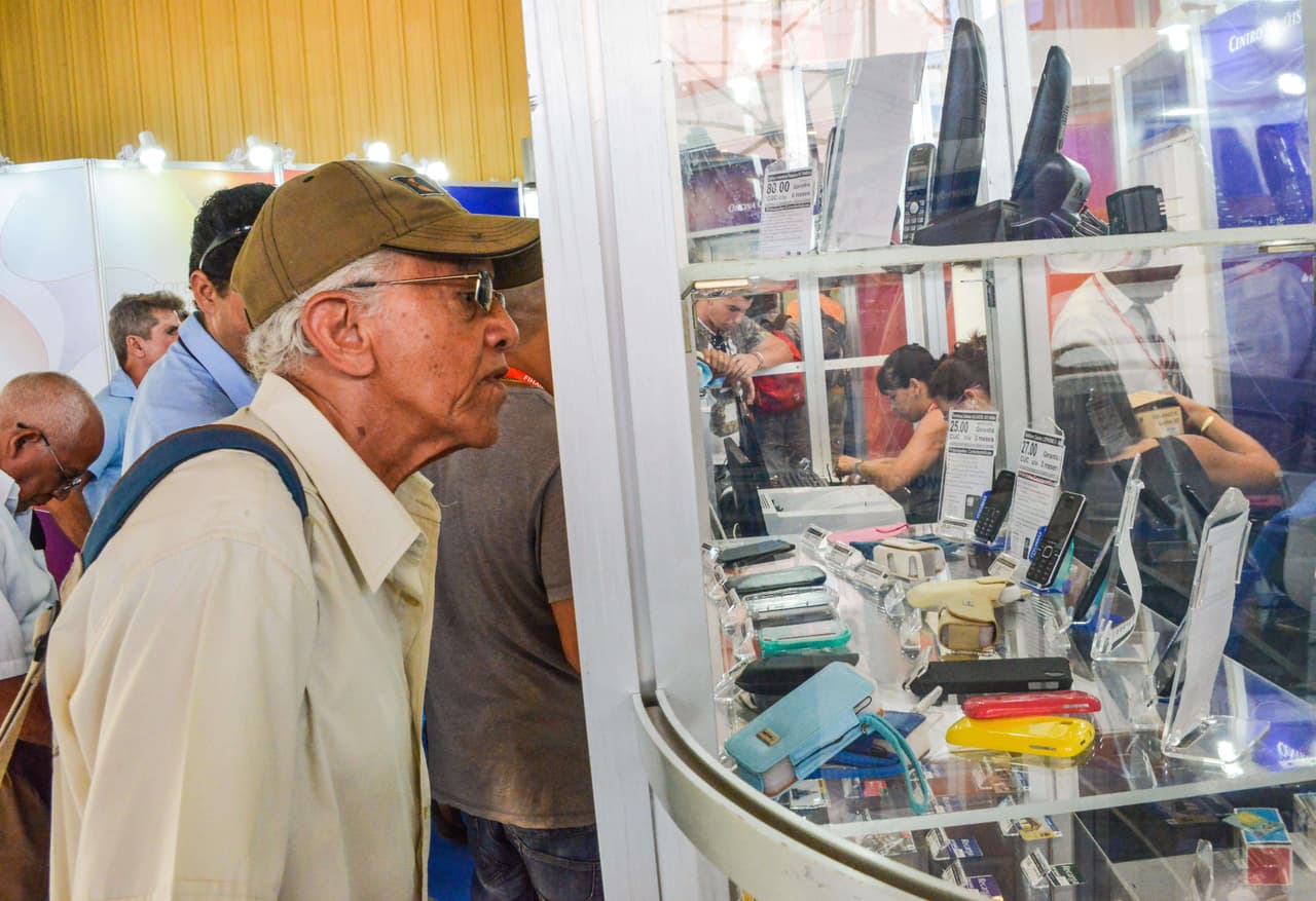 Un asistente a la Feria Internacional de La Habana mira ofertas de móviles.