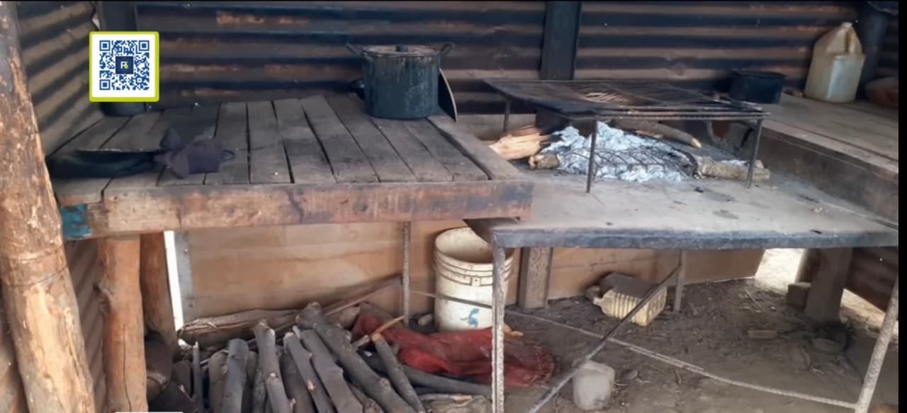 A un costado del autobús, la familia ha logrado acondicionar una precaria cocina con un fogón a leña donde se cocinan los pocos alimentos que pueden obtener de programas de asistencia social. El espacio para comer es pequeño y alcanza a penas para los tres miembros de la familia.