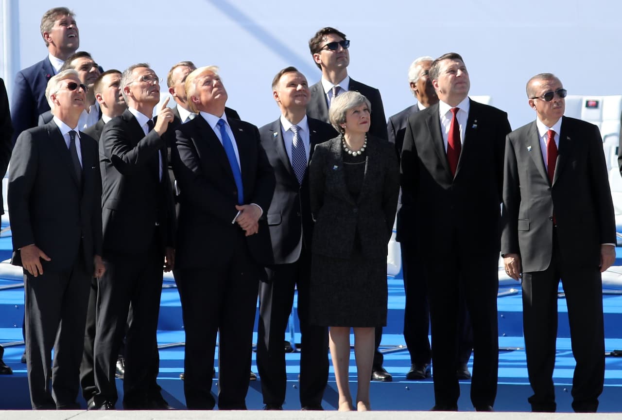 Los presidentes y jefes de gobierno de los países de la OTAN miran pasar un grupo de aviones militares como parte del evento de apertura de la nueva sede. El edificio fue construido donde antiguamente se encontraba un antiguo aeropuerto que fue bombardeado por fuerzas alemanas y aliadas en la segunda Guerra Mundial. En 2010 y 2011, se encontraron explosivos de la segunda guerra mundial sin detonar.
<br>