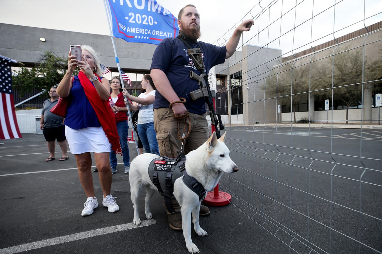 Este hombre armado espera a las afueras del Departamento de Elecciones de Maricopa luego de darse a conocer que Pennsyvania le dio el triunfo a Joe Biden.