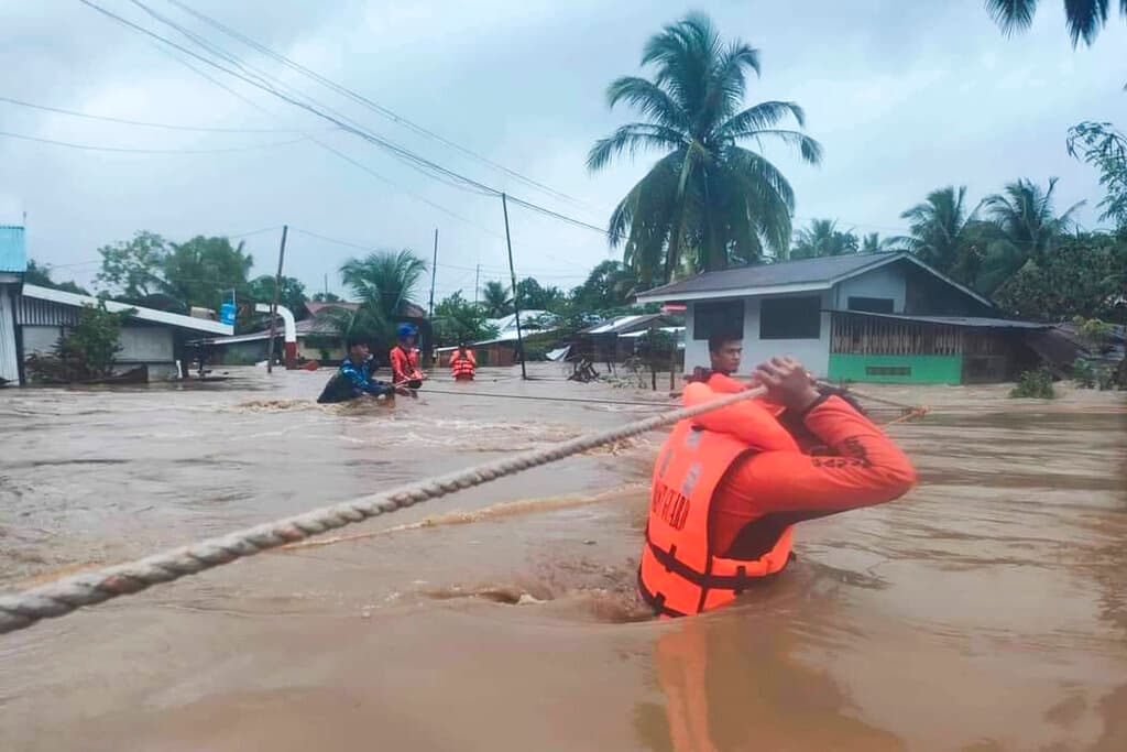 Rescatistas usan cuerdas para sacar a residentes de zonas inundadas en Parang, en donde las aguas subieron rápidamente, obligando a muchas personas a subirse a sus techos, de donde fueron rescatados.