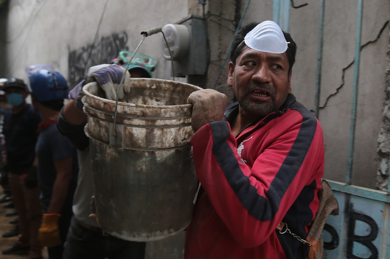 Mientras los expertos se cuelan por los escombros para encontrar sobrevivientes, los civiles voluntarios (como este en San Gregorio Atlapulco) se ocupan de la dura tarea de retirar escombros.