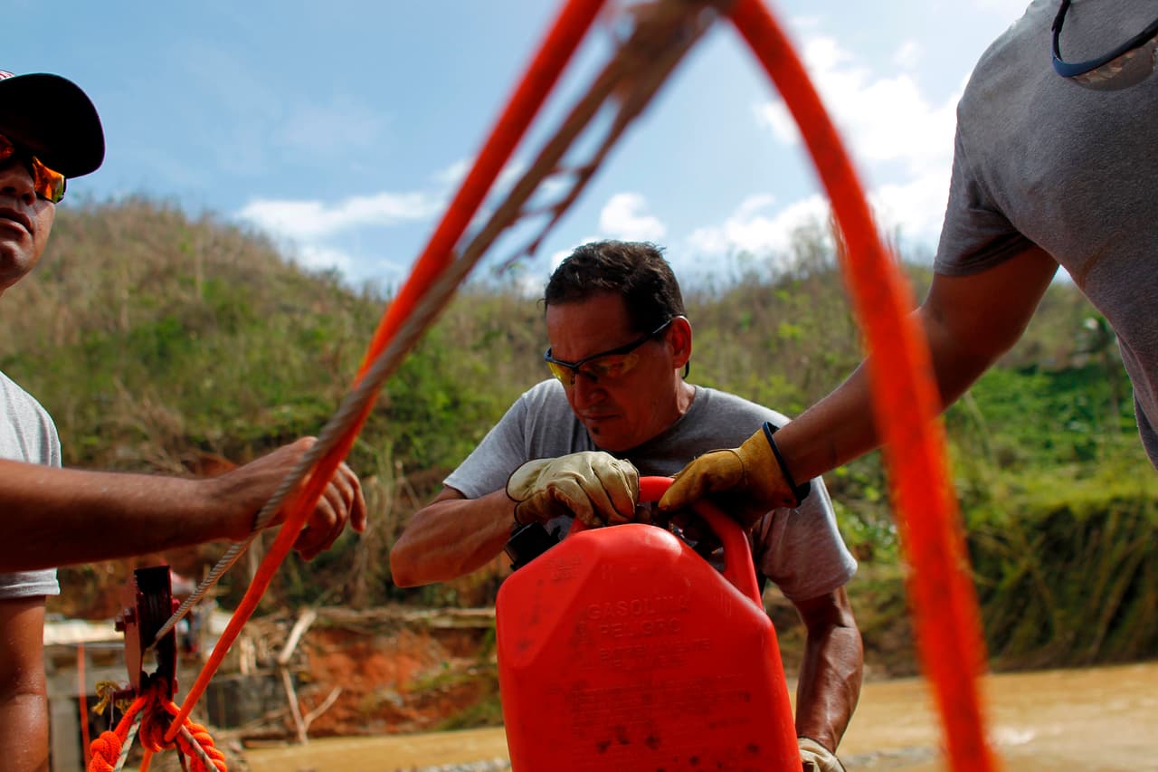 <b>Gasolineras: 78.64%.</b> Según el gobierno de Puerto Rico el servicio de las estaciones de gasolina se está normalizando. Sin embargo, en zonas aisladas como Utuado los residentes deben llevar el combustible cruzando barreras impuestas por los destrozos del huracán, en una fotografía del 17 de octubre de 2017.