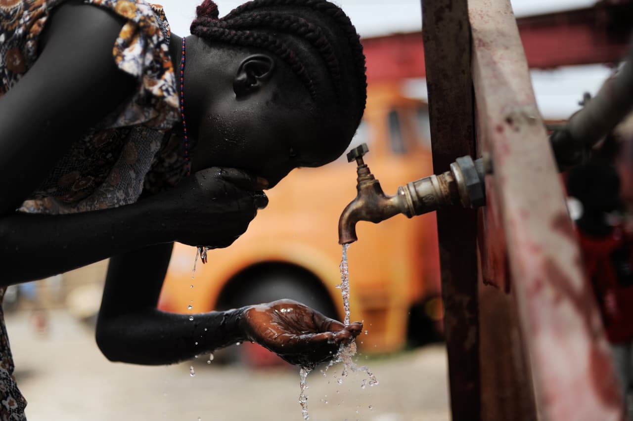 Una joven bebe agua de un tubo temporal. Funcionarios de Sudán del Sur están preocupados por el daño ambiental causado por la industria del petróleo en este país. Su región, que es potencialmente rica en recursos naturales pero muy subdesarrollada, se encuentra en un dilema: la gente pobre -en su mayoría agricultores de subsistencia y criadores de ganado- necesitan el dinero del petróleo, pero esta explotación está contaminando su agua. AFP / ROBERTO SCHMIDT