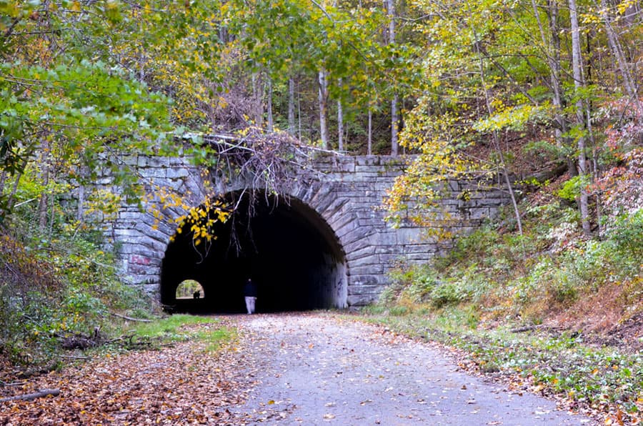 <b>ROAD TO NOWHERE</b>. “El Camino a Ninguna Parte” en español, es una carretera real en Bryson City que termina en un túnel dentro del Parque Nacional Great Smoky Mountains. Recibió su nombre de una disputa en las décadas de 1930 y 1940 cuando el condado de Swain cedió la mayoría de sus tierras privadas para que el gobierno federal pudiera crear Fontana Lake y Great Smoky Mountains National Park. La gente tuvo que mudarse, los cementerios familiares fueron cortados y la antigua carretera fue enterrada bajo las aguas del lago. El gobierno federal llegó a un acuerdo con el condado de Swain para construir una nueva carretera a lo largo de la costa norte del lago, pero los problemas ambientales detuvieron la construcción. Sin resolución, ahora décadas después, el camino todavía no lleva a ninguna parte. Más,
<b><a href="https://www.greatsmokies.com/road-nowhere/" target="_blank">aquí</a></b>.